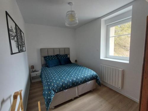 - une chambre avec un lit doté de draps bleus et une fenêtre dans l'établissement Agréable 3 pièces au Lac Blanc, à Orbey