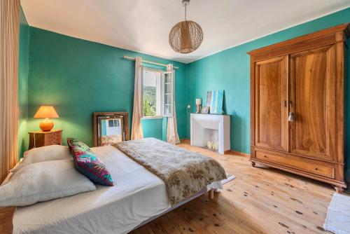 1 dormitorio con cama y pared verde en Maison Hyères Les Borrels Terrasse Vue Panoramique Macif des Maures, en Hyères