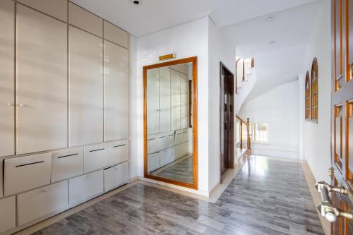 ein Ankleidezimmer mit weißen Schränken und einem Spiegel in der Unterkunft Dodeka Home in Athen