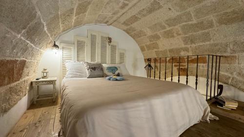 1 dormitorio con 1 cama grande en una pared de piedra en B&B Casa Fiore, en Polignano a Mare