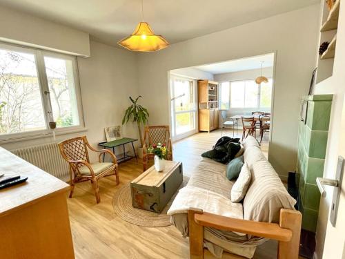 een woonkamer met een grote bank en een tafel bij Maison individuelle 100 m2, jardin et parking privé in Colmar