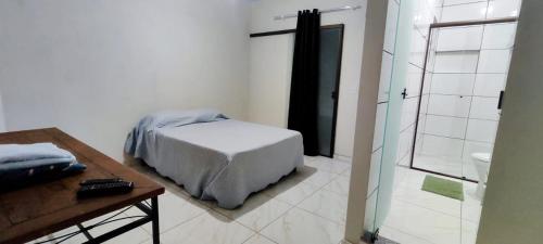 - une chambre avec un lit et une salle de bains pourvue d'une douche dans l'établissement Suítes Dona Maria de Tino, à Milho Verde