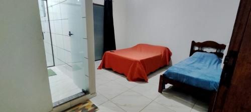 una camera con letto, sedia e specchio di Suítes Dona Maria de Tino a Milho Verde