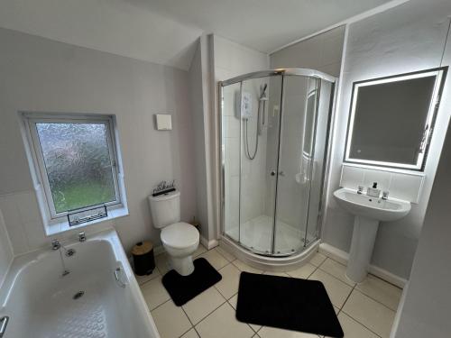 W łazience znajduje się prysznic, toaleta i umywalka. w obiekcie Impeccable 3-Bed House in Walsall w mieście Walsall