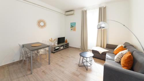 a living room with a couch and a table at Luciana Cannes avec parking - proximité centre croisette -gare -plage in Cannes