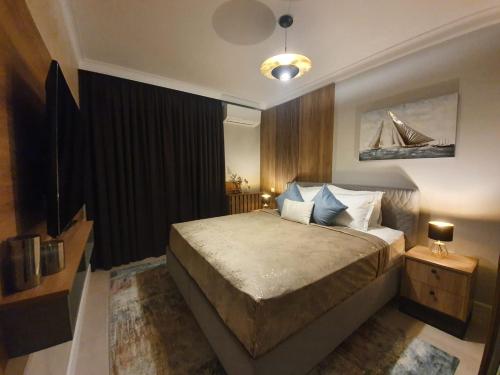 a bedroom with a large bed and a lamp at Tzuba Luxury Home Coresi Mall Brasov in Braşov