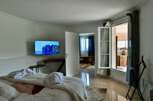 una camera con letto e TV a parete di Elégant-Cosy 2P55M2 dans bas de villa provençale ! a Villeneuve-Loubet
