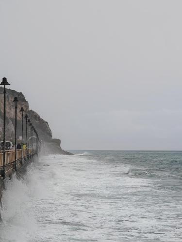 a beach with waves crashing on the shore at Il sogno di Jo a 50 mt dal mare in Borgio Verezzi