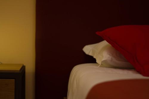 a bedroom with a bed with red and white pillows at Dimora De Mauro in Catania