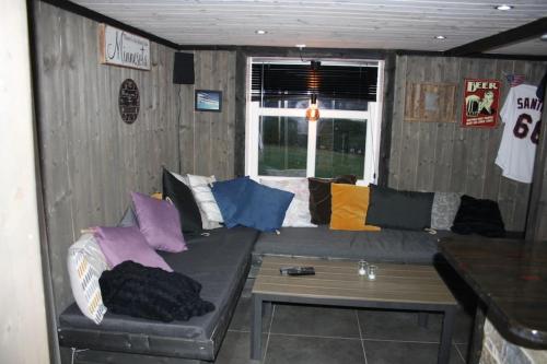 ein Wohnzimmer mit einem Sofa und bunten Kissen in der Unterkunft Koselig låve in Ålesund