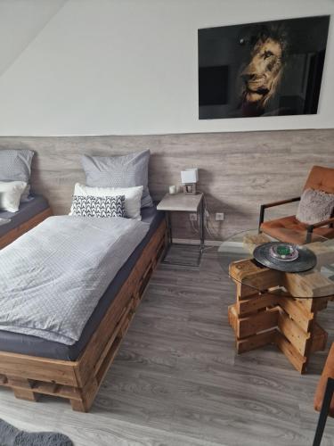 a bedroom with a large bed and a table at Schlafgut24 2 in Dortmund