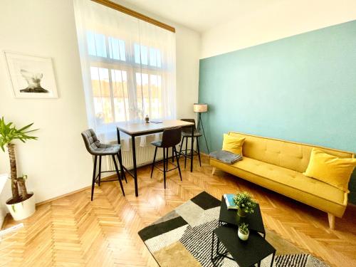 salon z żółtą kanapą i stołem w obiekcie StayHere City Apartment 36 w Grazu