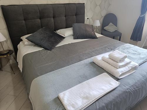 ein großes Bett mit zwei Handtüchern darüber in der Unterkunft Ruggiero's Rooms in Neapel