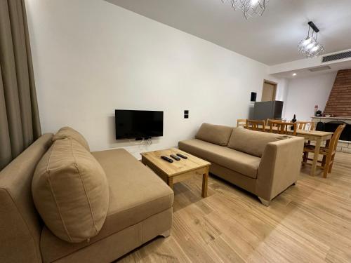 ein Wohnzimmer mit einem Sofa und einem Tisch in der Unterkunft Suites Kozi in Sarandë