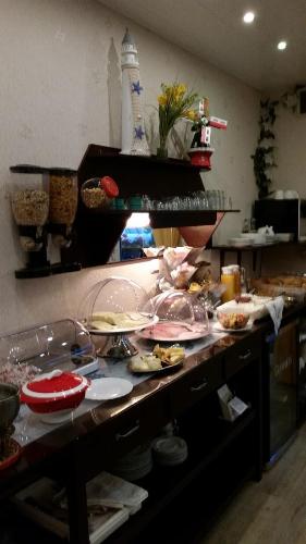 a kitchen counter with many plates and dishes on it at Pension am Kurgarten in Bensersiel