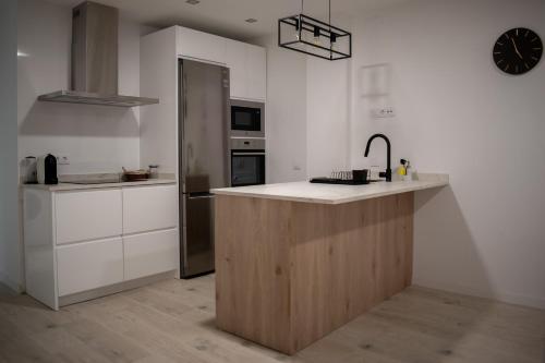 een keuken met een aanrecht met een wastafel en een klok bij Apartamento 'Koala21', Nuevo, Céntrico y con opción de parking in Jaén