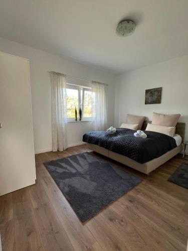 ein Schlafzimmer mit einem großen Bett und einem Fenster in der Unterkunft HOME OF VACATION - Ferienhaus bei Celle nähe Hannover - FREE WIFI & Netflix in Adelheidsdorf