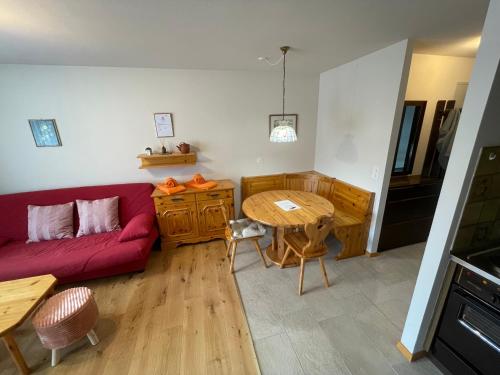 - un salon avec un canapé rouge et une table dans l'établissement Montanji 11, à Loèche-les-Bains