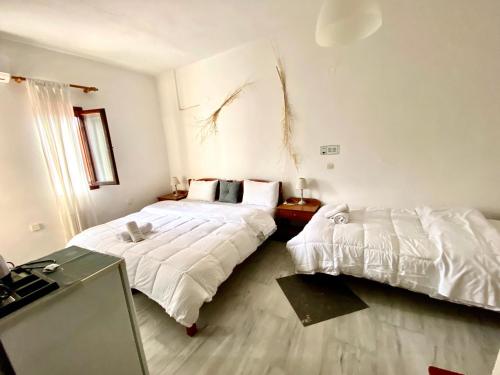 a bedroom with two beds with white sheets at Costas Inn in Spílion