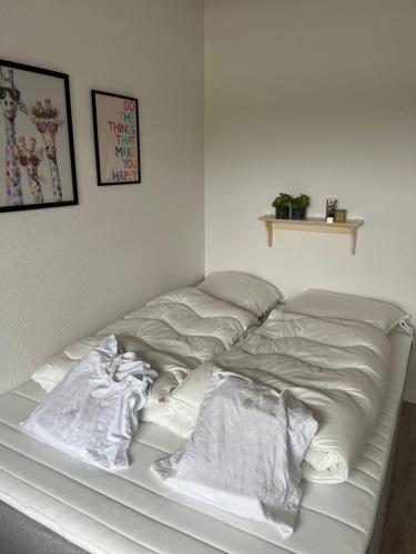 ein Bett mit weißer Bettwäsche und Kissen darauf in der Unterkunft Casa House of Bricks 2 - LEGOLAND 650m in Billund