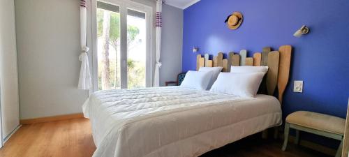 une chambre avec un grand lit avec un mur bleu dans l'établissement L'éden de Rosy proche de Carcassonne, à Alairac