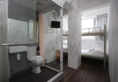 un letto e un bagno con doccia e servizi igienici. di Hop Inn a Hong Kong