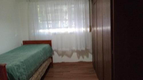 a bedroom with a bed and a window with curtains at La Plata 1643 in La Plata