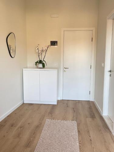 a room with a white door and a vase of flowers on a cabinet at Pisha Panoramic Rooms in Krujë