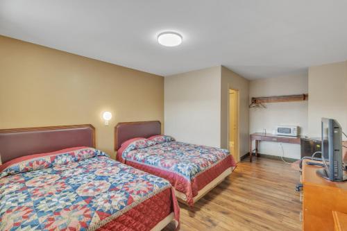 Cette chambre comprend 2 lits et une télévision à écran plat. dans l'établissement Viking Motel-Detroit, à Detroit