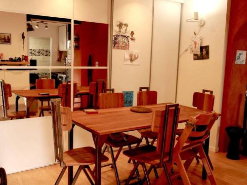 une salle à manger avec une table et des chaises en bois dans l'établissement Belle maison à Lagny, proche de Disney, à Lagny-sur-Marne