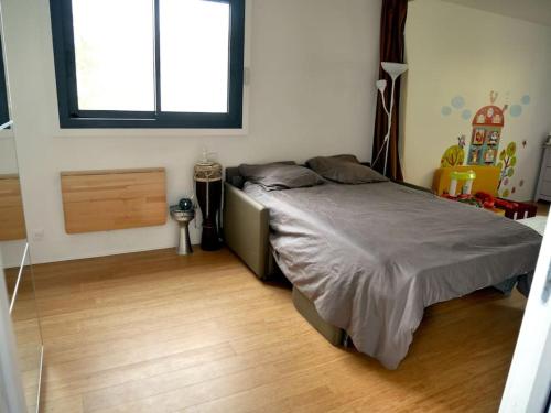 une chambre avec un lit et une fenêtre dans l'établissement Belle maison à Lagny, proche de Disney, à Lagny-sur-Marne