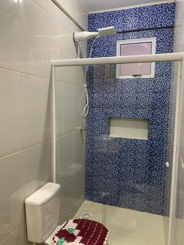 een badkamer met een toilet en een blauwe betegelde douche bij Pousada Thereza in Bento Gonçalves