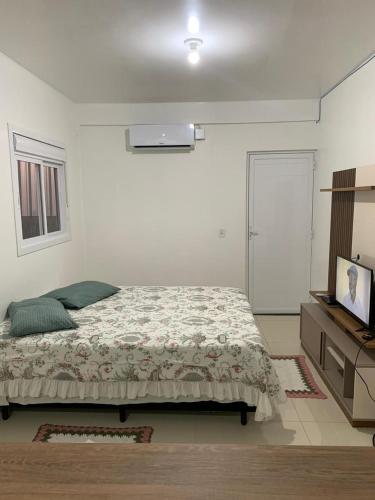 een slaapkamer met een bed, een dressoir en een televisie bij Pousada Thereza in Bento Gonçalves