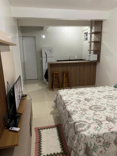 een slaapkamer met een bed en een keuken met een aanrecht bij Pousada Thereza in Bento Gonçalves