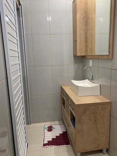 een badkamer met een wastafel en een spiegel bij Pousada Thereza in Bento Gonçalves