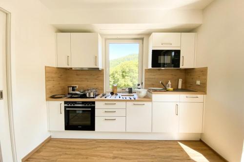 a kitchen with white cabinets and a window at 110 Lux Furnished flat in Beaufort