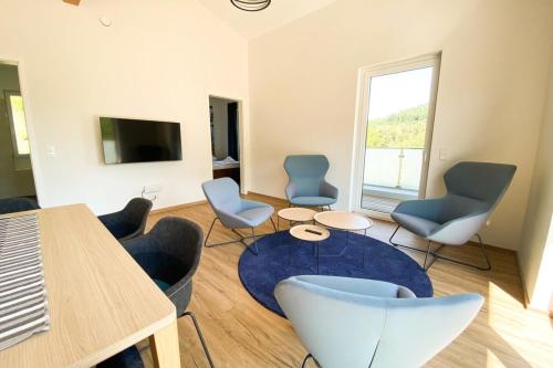 a living room with chairs and a table and a tv at 310 Lux Furnished flat in Beaufort