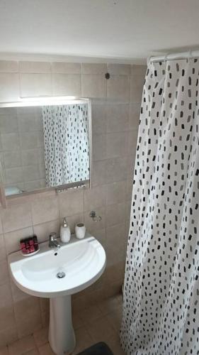 baño con lavabo y cortina de ducha en Cozy Nights, en Messini
