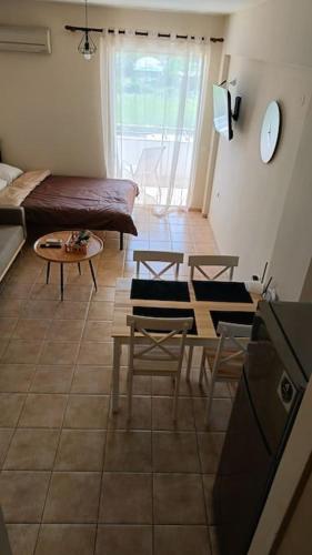 een woonkamer met een bed en een tafel en stoelen bij Cozy Nights in Messini
