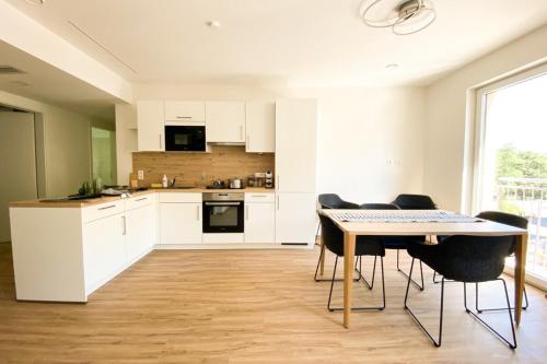a kitchen with white cabinets and a table and chairs at 110 Lux Furnished flat in Beaufort
