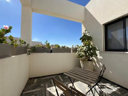 - un balcon avec un banc et des plantes dans un bâtiment dans l'établissement צימר אירוס ירוחם, à Yeruham