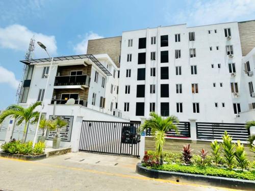 a white building with palm trees in front of it at Rod Apartments in Lagos