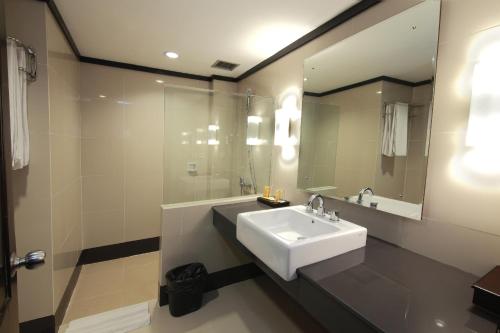 La salle de bains est pourvue d'un lavabo et d'un miroir. dans l'établissement Pangeran Beach Hotel, à Padang