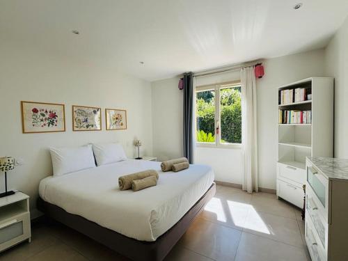 une chambre blanche avec un grand lit et une fenêtre dans l'établissement Villa au charme provençal avec piscine à St Paul, à Saint-Paul-de-Vence