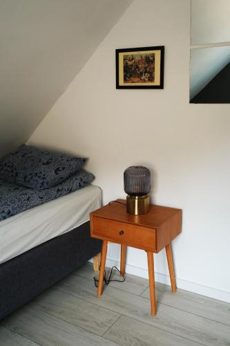 a room with a bed and a table with a lamp on it at Vík Hostel in Vík
