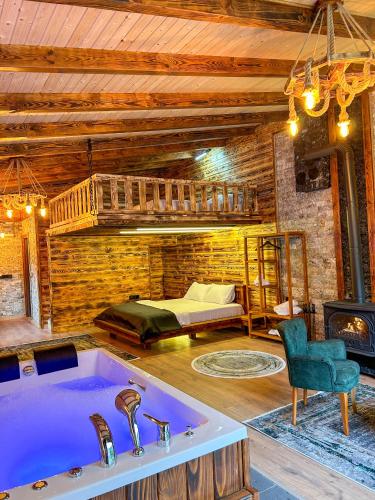 a bathroom with a tub and a bed in a room at Dayf Suit Naliya Otel in Çamlıhemşin