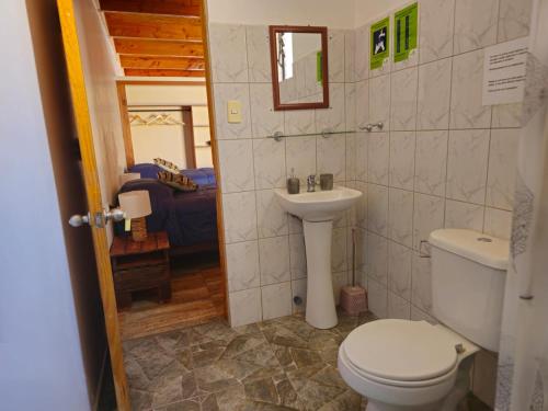 y baño con aseo y lavamanos. en Hostal Belen en San Pedro de Atacama