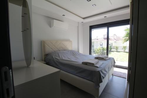 a bedroom with a bed and a large window at Marin Villaları Villa-2 in Marmaris