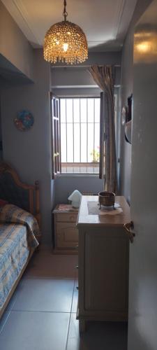 a room with a kitchen with a table and a window at Los nietos alojamiento céntrico in San Miguel de Tucumán