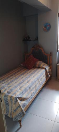 Una cama con una manta en un dormitorio en Los nietos alojamiento céntrico en San Miguel de Tucumán